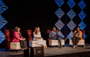 A group of panelists speak on the mainstage