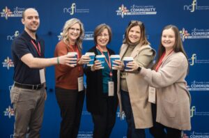 A group of attendees share a toast with their morning coffee